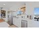 Well-lit kitchen with stainless steel appliances, white cabinets, quartz countertops, and open shelving at 13020 N 18Th St, Phoenix, AZ 85022