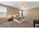 Comfortable bedroom with large windows, neutral carpet, and a ceiling fan at 13612 W Desert Moon Way, Peoria, AZ 85383