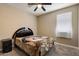 Cozy bedroom featuring a comfortable bed, neutral walls, a ceiling fan, and a window for natural light at 13612 W Desert Moon Way, Peoria, AZ 85383