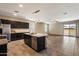 Modern kitchen with granite countertops, dark cabinetry, and island with bar seating at 13612 W Desert Moon Way, Peoria, AZ 85383