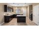 Modern kitchen with granite countertops, dark wood cabinets, stainless steel appliances, and a center island at 13612 W Desert Moon Way, Peoria, AZ 85383