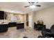 Open-concept living room and kitchen area with tile flooring, dark cabinetry and a cozy sitting area at 13612 W Desert Moon Way, Peoria, AZ 85383