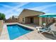 Backyard pool featuring lounge chairs and an umbrella with sunny backyard scenery at 13612 W Desert Moon Way, Peoria, AZ 85383
