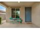 Inviting front porch with cozy seating area, perfect for enjoying the outdoors and a blue front door at 17573 W Via De Luna Dr, Surprise, AZ 85387