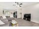 Inviting living room with ample natural light, plush carpeting, and a modern entertainment center at 17573 W Via De Luna Dr, Surprise, AZ 85387