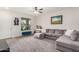 Living room featuring a large sectional couch, light gray carpet, and a window letting in natural light at 17573 W Via De Luna Dr, Surprise, AZ 85387