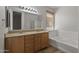 Bathroom with double sink vanity, soaking tub, and large mirror with vanity lights at 18391 W Stinson Dr, Surprise, AZ 85374