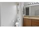Well-lit bathroom boasts wood cabinetry, a beige countertop, and a convenient toilet area at 18391 W Stinson Dr, Surprise, AZ 85374