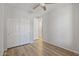 Bedroom with wood-look flooring, a ceiling fan, and a spacious double closet at 18391 W Stinson Dr, Surprise, AZ 85374