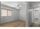 This bedroom features a ceiling fan and a window with wood-toned blinds and wood floors at 18391 W Stinson Dr, Surprise, AZ 85374
