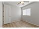 Bright bedroom featuring a ceiling fan, window with blinds, wood-look flooring, and neutral wall paint at 18391 W Stinson Dr, Surprise, AZ 85374