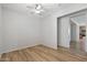 This bedroom features a ceiling fan, light gray walls, and wood-look flooring at 18391 W Stinson Dr, Surprise, AZ 85374