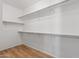 A walk-in closet with wood-look flooring and white shelving at 18391 W Stinson Dr, Surprise, AZ 85374