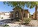 Charming tan home exterior features a tile roof, desert landscaping, and window details at 18391 W Stinson Dr, Surprise, AZ 85374