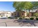 Single-story home featuring well-maintained desert landscaping and mature shade trees at 18391 W Stinson Dr, Surprise, AZ 85374