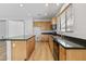 Well-lit kitchen with wood cabinets, dark countertops, island, and modern appliances at 18391 W Stinson Dr, Surprise, AZ 85374