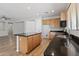 Spacious kitchen featuring a central island with dark countertop, wood cabinets, and modern stainless steel appliances at 18391 W Stinson Dr, Surprise, AZ 85374