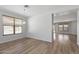 Bright living room featuring wood-look floors, neutral walls, and access to other living areas at 18391 W Stinson Dr, Surprise, AZ 85374