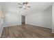 Bright living room with modern ceiling fan, wood-look floors, and neutral walls, offering a versatile space at 18391 W Stinson Dr, Surprise, AZ 85374