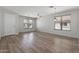 Bright living room with wood-look floors, ceiling fan, and multiple windows providing natural light at 18391 W Stinson Dr, Surprise, AZ 85374