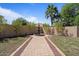 Private backyard featuring a decorative fountain, lush landscaping, and a charming walkway creating a serene oasis at 20638 W Main St, Buckeye, AZ 85396