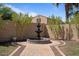 Enchanting backyard oasis with a central water fountain, mature trees, and meticulous landscaping for ultimate relaxation at 20638 W Main St, Buckeye, AZ 85396
