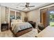 Comfortable bedroom featuring soft lighting, a ceiling fan, and easy access to outdoor spaces at 20638 W Main St, Buckeye, AZ 85396