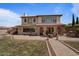 Expansive two-story home with a stone facade, arched entryway, and ample outdoor seating areas for entertaining at 20638 W Main St, Buckeye, AZ 85396