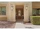 Inviting front entrance with a decorative wood door, stylish lanterns, and manicured shrubs at 20638 W Main St, Buckeye, AZ 85396