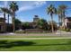 Verrado Golf Club features lush landscaping and a welcoming entrance with a sign, trees, and flowers at 20638 W Main St, Buckeye, AZ 85396