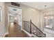 Bright hallway with hardwood floors, iron banister, decorative mirror, and a glimpse of a sunlit bedroom at 20638 W Main St, Buckeye, AZ 85396
