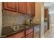 Kitchen wet bar with a beverage cooler, sink, black countertops, and decorative backsplash at 20638 W Main St, Buckeye, AZ 85396