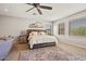 Comfortable main bedroom featuring a stylish rug, tufted headboard, and ample natural light from three windows at 20638 W Main St, Buckeye, AZ 85396