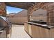 Outdoor kitchen featuring a granite countertop and backsplash, stainless steel grill, and stone accents at 20638 W Main St, Buckeye, AZ 85396