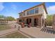Inviting backyard patio featuring a stone fireplace and outdoor seating under a covered area of the home at 20638 W Main St, Buckeye, AZ 85396