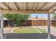 View of the backyard from under the covered patio showing artificial turf and wooden fence at 20644 N 30Th Dr, Phoenix, AZ 85027