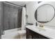 A bathroom featuring modern vanity, round mirror, and shower with unique gray tiling at 20644 N 30Th Dr, Phoenix, AZ 85027