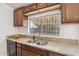 A kitchen featuring stainless steel sink, granite countertops, and wooden cabinets at 20644 N 30Th Dr, Phoenix, AZ 85027