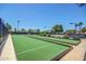 An outdoor bocce ball court features synthetic turf, and bordered by green landscaping at 215 N Power Rd # 33, Mesa, AZ 85205