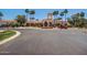 A community clubhouse features a roundabout, manicured landscaping, and tile roof at 215 N Power Rd # 33, Mesa, AZ 85205