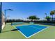 Community pickleball court with blue surface, net, and lighting, providing an inviting space for active recreation at 215 N Power Rd # 33, Mesa, AZ 85205