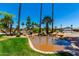 Scenic pond with a bridge, rock features, and lush tropical landscaping at 215 N Power Rd # 33, Mesa, AZ 85205