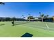 Outdoor tennis court featuring well-maintained green surface, net, and lighting for evening play at 215 N Power Rd # 33, Mesa, AZ 85205