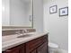 A bathroom featuring an integrated sink, dark wood cabinetry, a decorative faucet, and framed art at 2308 E Aster Dr, Chandler, AZ 85286