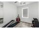 Bedroom featuring a total gym set, wood-look floors, a ceiling fan, and natural light from a window at 2308 E Aster Dr, Chandler, AZ 85286