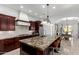 A kitchen boasting dark cabinetry, stainless appliances, granite countertops, and an island with seating, open to the dining area at 2308 E Aster Dr, Chandler, AZ 85286