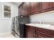 Laundry room featuring a gray washer and dryer set and built in dark cabinets with a white sink at 2308 E Aster Dr, Chandler, AZ 85286