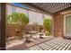 Comfortable covered patio featuring a stone wall and wrought iron seating perfect for enjoying the outdoor weather at 2308 E Aster Dr, Chandler, AZ 85286
