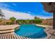 Inviting backyard pool featuring clear blue water, stone accents, and lush landscaping against a bright sky at 2308 E Aster Dr, Chandler, AZ 85286