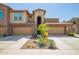 Inviting townhome featuring two-car garage, desert landscaping, and charming architectural details at 2425 W Bronco Butte Trl # 2028, Phoenix, AZ 85085